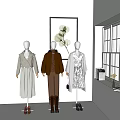 Three Mannequins Displaying Stylish Outfits With Accessories Near Window And Decorative Painting
