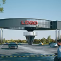 Modern Architectural Entrance Gate with Red Logo Metal Supporting Pillars Green Trees and Cars