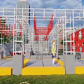Outdoor Children's Playground With Red Climbing Frames Yellow Platforms And Green Lawn