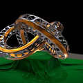 Intricate Metal Sculpture Featuring Intertwined Perforated Rings And Green Reflective Base