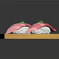 Two Pieces of Pink Sushi Placed on Wooden Board With Green Garnish