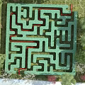 Fun Outdoor Playground With Green Maze And Red Paths Surrounded By Trees