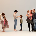 Group of People Interacting Indoors With Adults Dressing Children And Hugging