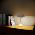 Minimalist Table Lamp Emitting Soft Light On Wooden Bookshelf With Books
