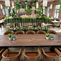 Open Space Restaurant With Wooden Ceiling Hanging Green Plants Pendant Lights And Red Brick Walls