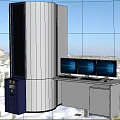 White Cylindrical Medical Equipment With Blue Side Panel And Three Monitors On White Desk