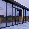 Modern Building Exterior With Glass Doors Windows And Outdoor Terrace Wicker Chairs Gray Tile Floor