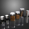 Clear Glass Kitchen Storage Jars With Silver Lids Holding Spices And Dried Ingredients On Black Surface