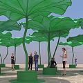Giant Green Lotus Leaf Art Installation With People Walking Around Public Space