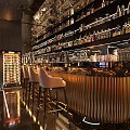 Modern Bar Interior with Metallic Counter Bar Stools and Wine Racks Full of Bottles