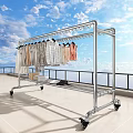 Metal Clothes Rack With Wheels Hanging Various Clothes On Balcony Blue Sky Background