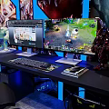 Gaming Desk Setup With Dual Monitors Displaying Gameplay Keyboard Mouse And Figurines