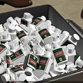 Bulk White Medical Device Bottles With Green And White Labels In Storage