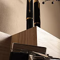Wooden Desk Setup With Table Lamp Books Chair And Framed Artwork By Window With Blinds