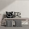 Decorative Black and White Pillows with Abstract Striped Zigzag Patterns on Light Wood Bench