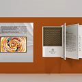 Art Installation Featuring Orange Display Wall Open Book Structure Colorful Painting Text Panels And Viewer