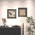 Framed Abstract Paintings With Floral Patterns On White Wall Near Black Cabinet And Green Plants