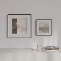 Minimalist Interior With Two Black Framed Abstract Paintings Brown Beige Light Table Books Cup Phone