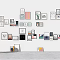 Assorted Framed Wall Art Display On White Wall With People Silhouettes