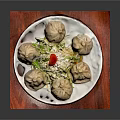 Delicious Steamed Dumplings on White Plate with Red Placemat and Lettuce Garnish
