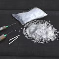White Powder Scattered With Syringes And Metal Spoons On Dark Surface