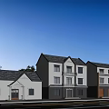 Two Story Detached Villa With White Exterior Dark Roof Multiple Windows Front Driveway And Trees
