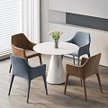Modern White Round Table Set With Four Brown And Blue Chairs And Flower Vase