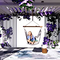 Pergola Decorated with Purple Flowers and Hammock Where Person Sits on Stone Floor