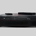 Modern Black Entertainment Media Player With Remote Control And Cassette Tape On Top