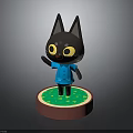 Black Cartoon Cat Figurine Wearing Blue Shirt Standing On Round Green Base With Red Edge