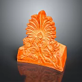 Orange Carved Decorative Ornament With Plant Inspired Floral Patterns And Swirls