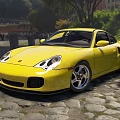 Yellow Porsche Sports Car Parked On Cobblestone Road With Trees And Buildings In Background