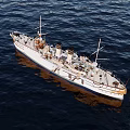Vintage White Yacht With Gold Accents Sailing On Ocean Under Cloudy Sky