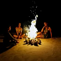 Garden Ornaments Enhance Bonfire Gathering With People Sitting On Sand At Night