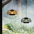 Modern Pendant Lights With Domed Amber And Smoke Shades Against Natural Forest View