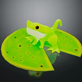 Green Frog Toy Sitting On Green Leaf With Holes Transparent Body And Black Eyes