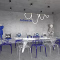 Modern Interior Space Featuring Transparent Chairs Blue Bases White Table Collectible Figures And Pendant Lights