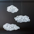 Delicate Cloud Shaped Chandeliers With Lace Design And White Lights Hanging In Dark Background