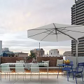 Home Balcony With White Umbrella Blue Chairs Table And City Sunset View