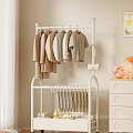 White Clothes Rack With Hanging Coats T Shirts And Pants Near Drawer Cabinet Lamp Vase