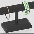 Elegant Gold Thin Bracelet And Green Beaded Jewelry On Black Display Stand