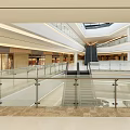 Shopping Mall Atrium With Glass Skylight Blue Sky White Clouds Multiple Floors Glass Railings Shops