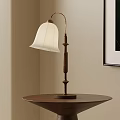 Classic Table Lamp With White Lampshade And Curved Wooden Base On Brown Round Table