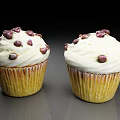Delicious Cupcakes Topped With White Frosting And Chocolate Chips On A Reflective Dark Surface