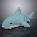 Light Blue Stuffed Shark Toy With White Underbelly And Black Eyes On Reflective Surface