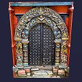 Intricately Carved Black Entrance Gate With Red Brick Walls And Colorful Decorations
