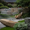 Tranquil Japanese Garden Landscape With Stone Sculptures Misty Pathway And Lush Greenery