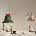 Green Bell Lamp With Red Bow And Beige Curved Lamp With Open Book Glass Saucer
