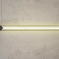 Modern Linear Chandelier With White Light Hanging In Concrete Wall Interior