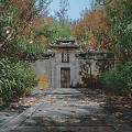 Traditional Chinese Gateway With Classic Roof Plaque And Golden Autumn Leaves Around Stone Walls